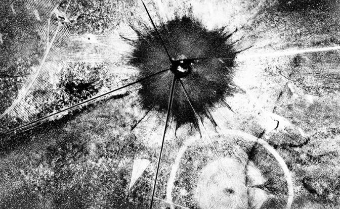 На фото: вид с воздуха на последствия первого атомного взрыва на полигоне Тринити, штат Нью-Мексико, 16 июля 1945 года. От него остался кратер шириной в полмили и десять футов глубиной у выходного отверстия, а песок внутри кратера был выжжен