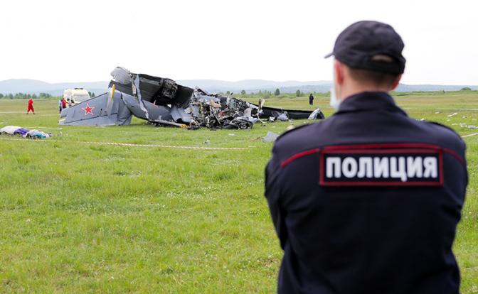 На фото: сотрудник полиции на месте падения легкомоторного самолета L-410 в районе кузбасского аэродрома Танай.
