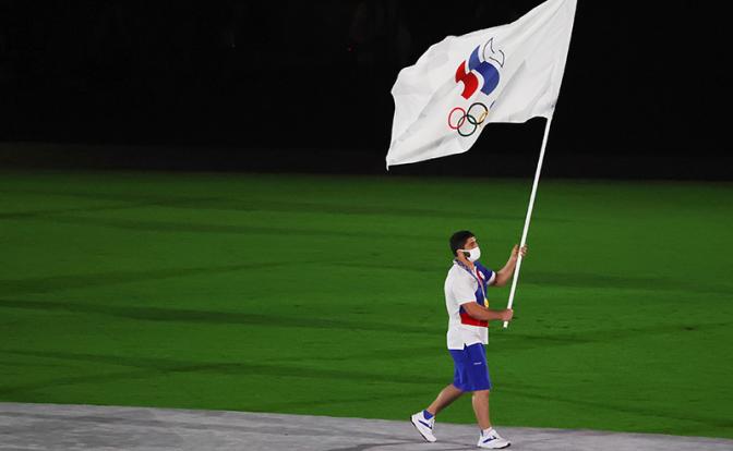 На фото: знаменосец команды ОКР борец Абдулрашид Садулаев во время парада атлетов на церемонии закрытия на Национальном олимпийском стадионе.