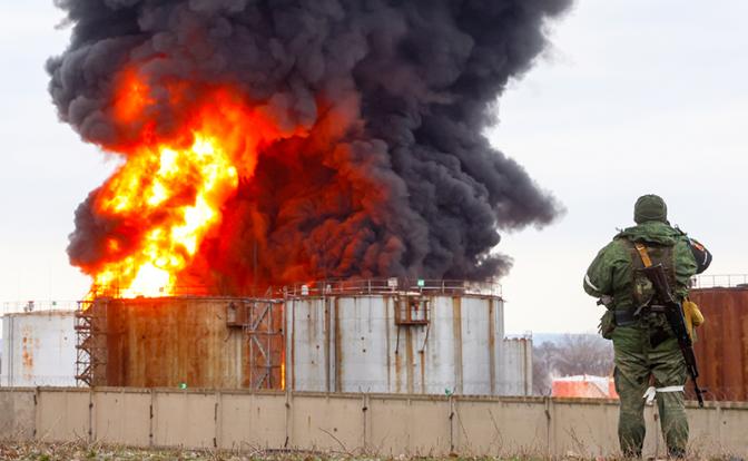 На фото: военнослужащий возле Луганской нефтебазы во время пожара.