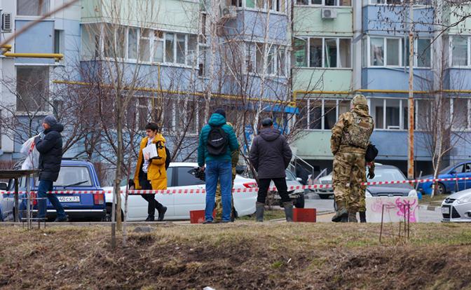 На фото: люди у здания и машин, поврежденных в результате обстрела со стороны ВСУ.