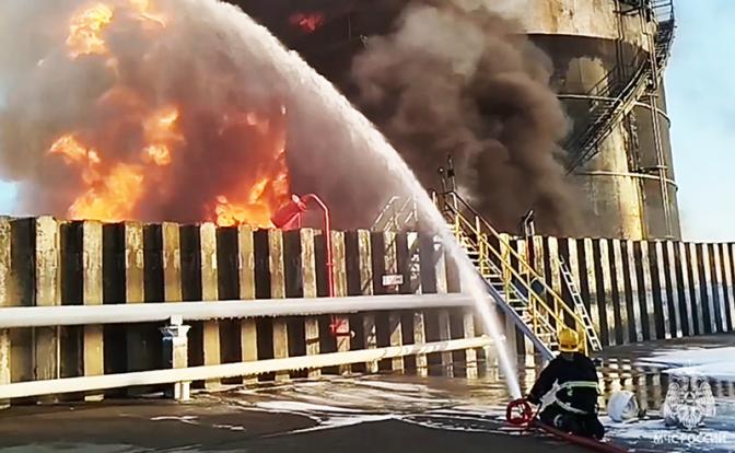 На фото: сотрудники МЧС РФ во время тушения возгорания резервуара с нефтепродуктами.