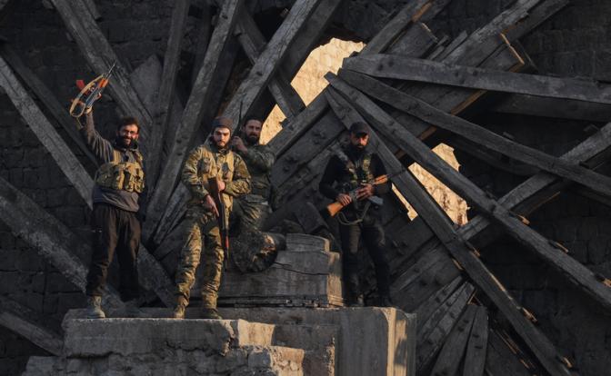 На фото: боевики-повстанцы празднуют победу после захвата города оппозицией в центре Хамы, Сирия.