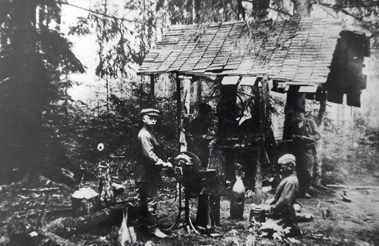 На фото: начальник оружейной мастерской партизанского отряда им. Громова бригады им. Чкалова Слуцкого района Н. Мысник (1-й слева) в мастерской, 1943 год. 