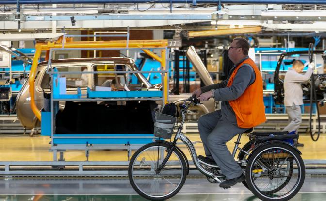 На фото: сотрудник на велосипеде на линии сборки Lada Vesta на автомобильном заводе "Автоваз".
