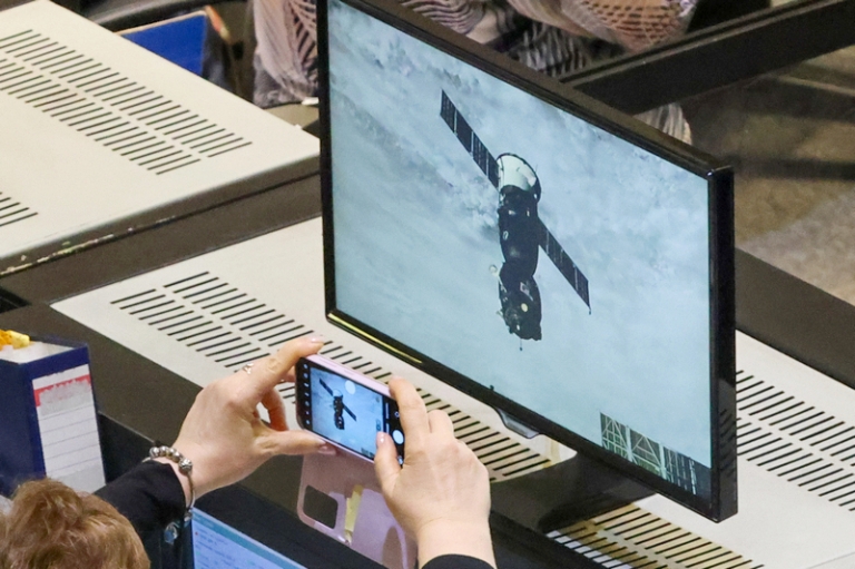 На фото: струдник фотографирует трансляцию стыковки корабля "Союз МС-27" с МКС в Центре управления полетами (ЦУП) Госкорпорации "Роскосмос".