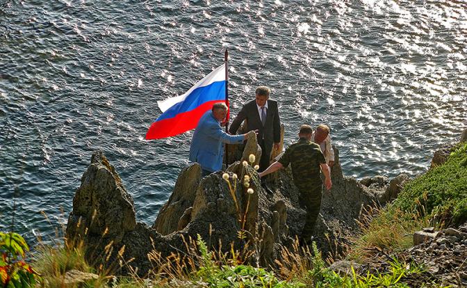 На фото: установка российского флага на острове Кунашир на Южных Курилах.