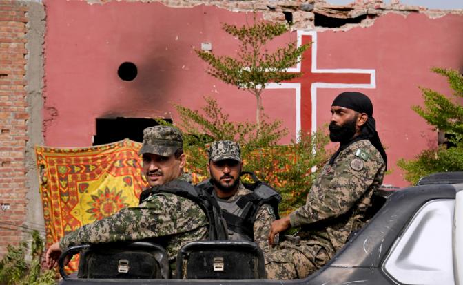 На фото: вооруженный патруль возле сгоревшей церкви в Пакистане.