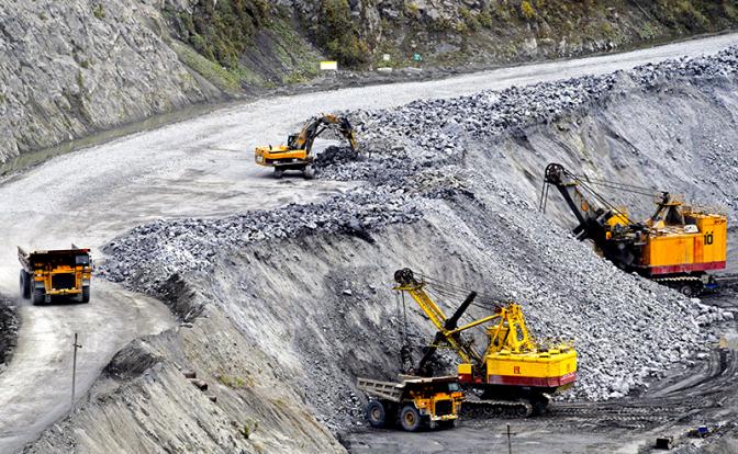 На фото: работа карьерных самосвалов и экскаваторов в карьере рудника, Мурманская область.