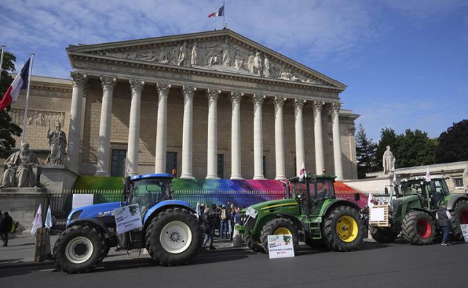 На фото: фермеры на тракторах протестуют в Париже у здания Национального собрания