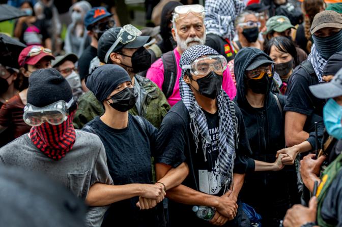 На фото: протестующие проводят митинг и пытаются остановить транспортировку иммигрантов от Федеральной площади Иммиграционного суда.