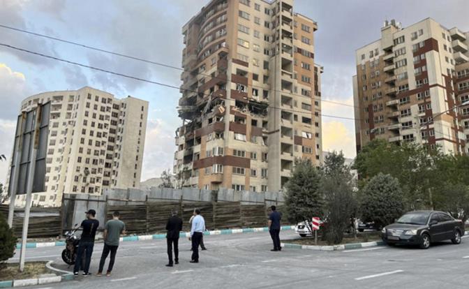 На фото: жители наблюдают за поврежденными домами в Тегеране, Иран