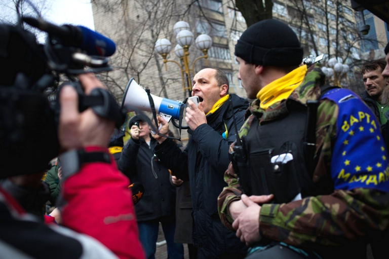 На фото: комендант Майдана, народный депутат Андрей Парубий и антиправительственные активисты из группы &laquo;Самооборона 14 сотен&raquo; принимают участие в акции протеста перед зданием Генеральной прокуратуры в Киеве, 2014 год.