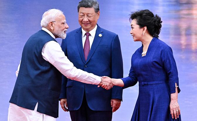 На фото: премьер-министр Индии Нарендра Моди, председатель КНР Си Цзиньпин и супруга председателя КНР Пэн Лиюань (слева направо) во время совместного фотографирования на церемонии официального приветствия глав делегаций