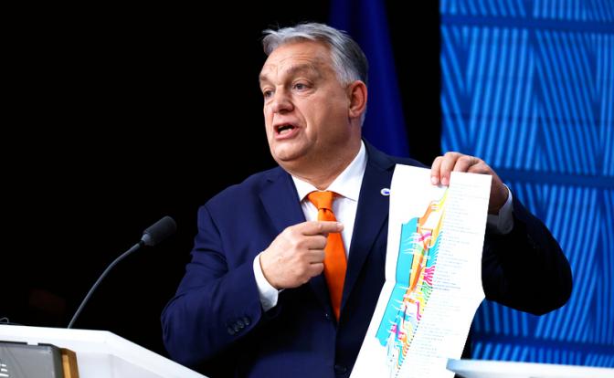 На фото: премьер-министр Венгрии Виктор Орбан держит брошюру о будущем Европы, выступая на пресс-конференции по итогам саммита ЕС в Брюсселе.