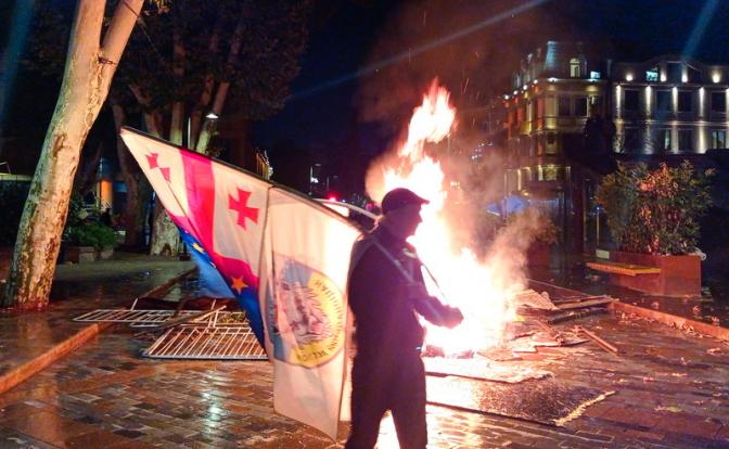 На фото: протестующие у резиденции президента Грузии подожгли навесы и скамейки близлежащих кафе.