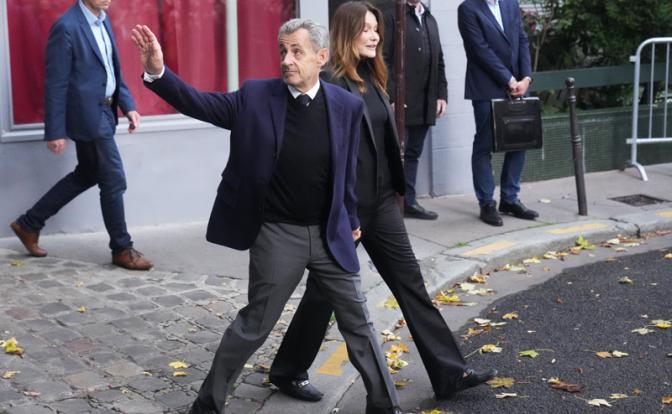 На фото: бывший президент Франции Николя Саркози (2007-2012 гг.) и бывшая первая леди Франции Карла Бруни-Саркози выходят из своего дома. Николя Саркози отправляется в парижскую тюрьму Санте.