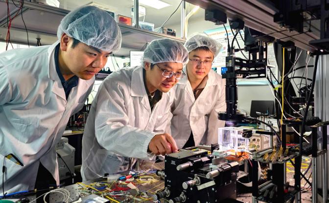 На фото: профессор Пекинского университета, тестирует интегрированный фотонный квантовый чип вместе с докторантами Цзя Синьюй (слева) и Чжай Чунхао в лаборатории Пекинского университета в Пекине, Китай.