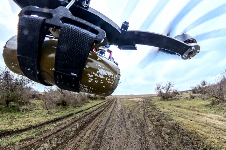 На фото: FPV-дрон с противопехотной осколочной миной (ПОМ) во время дистанционного минирования дороги на территории противника в зоне СВО.