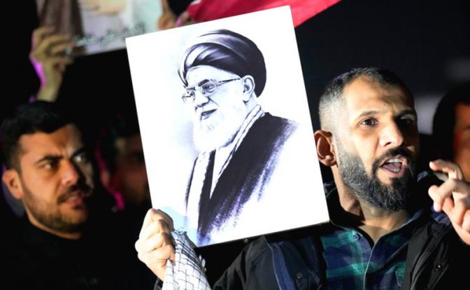 На фото: люди держат портрет верховного лидера Ирана аятоллы Али Хаменеи во время протеста против атак США и Израил/.