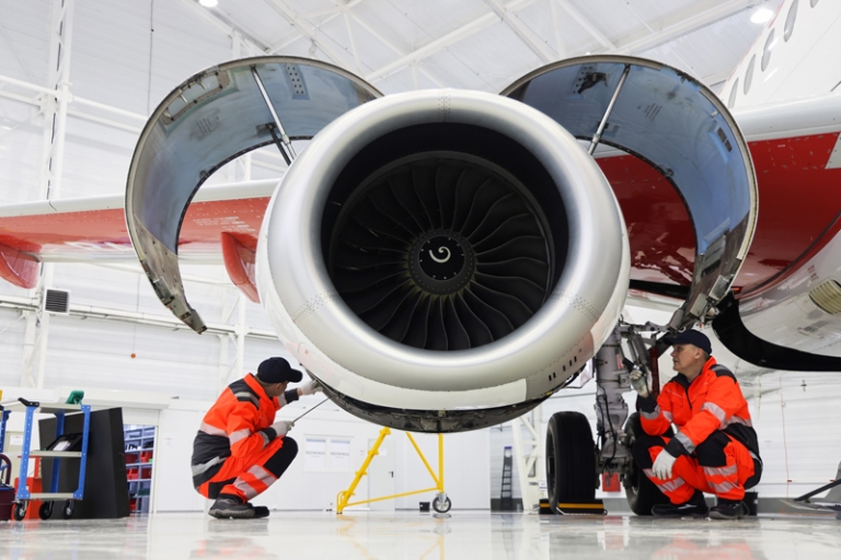 На фото: сотрудники ангара во время проверки систем двигателей самолета Sukhoi SuperJet 100 на линейной станции оперативного технического обслуживания воздушных судов.