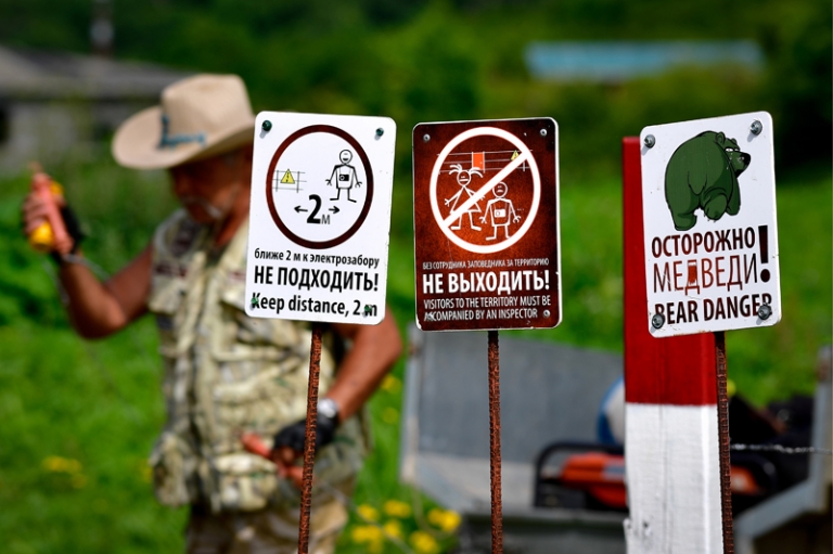 На фото: таблички с правилами безопасности при встрече с дикими животными.