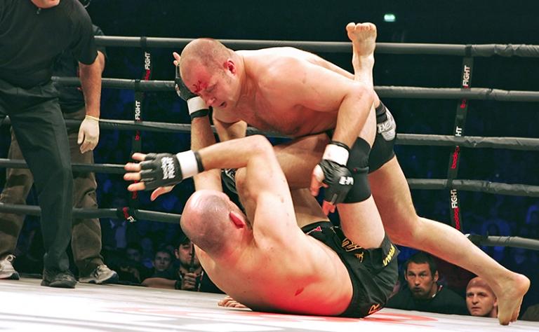 На фото: абсолютный чемпион мира по микс-файтингу, россиянин Федор Емельяненко (сверху) и американец Мэт Линдлэнд (снизу) во время турнира по микс-файту "Россия против Америки" во Дворце спорта "Ледовый", 2007