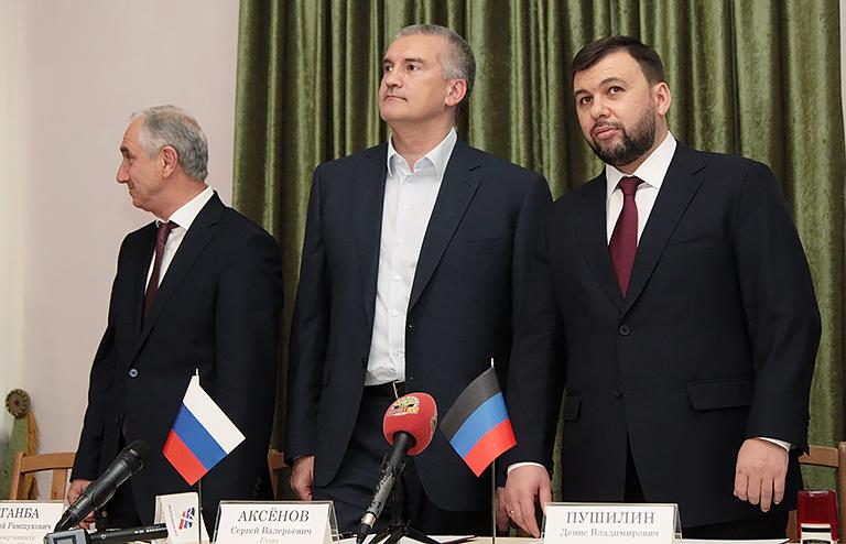 На фото: премьер-министр Абхазии Валерий Бганба, глава Крыма Сергей Аксенов и глава ДНР Денис Пушилин (слева направо) во время церемонии гашения конверта первого дня, посвященного инаугурации Д. Пушилина в Донецком государственном академическом театре оперы и балета имени Соловьяненко