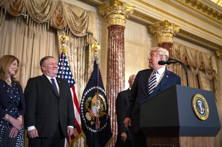 На фото: президент США Дональд Дж. Трамп выступает перед присягой Майка Помпео, государственного секретаря США, в Государственном департаменте в Вашингтоне, округ Колумбия, США, 2018 год. Рядом с Помпео его жена, Сьюзан Помпео. 