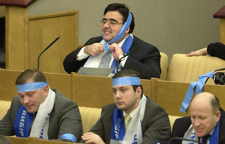 На фото: депутаты фракции ЛДПР: Александр Курдюмов, Алексей Островский, Олег Малышкин (слева направо) и Алексей Митрофанов (на втором плане) выражают поддержку Виктору Януковичу во время заседания Госдумы РФ, 2004