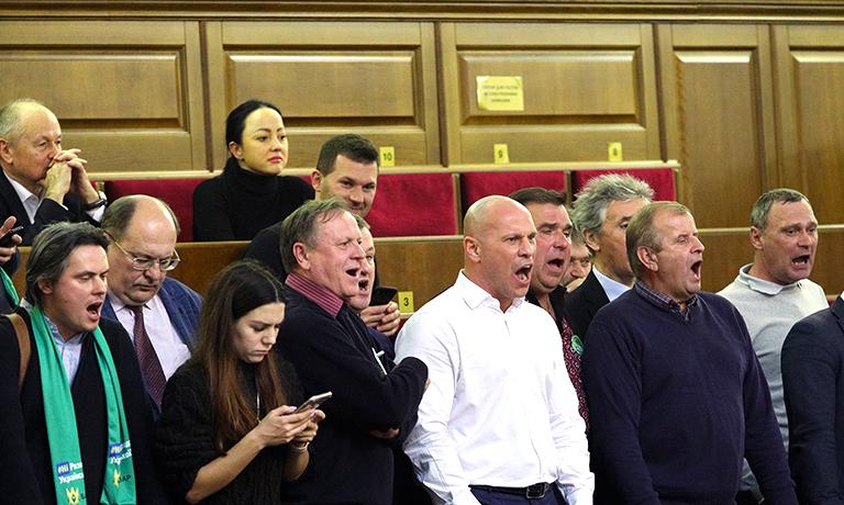 На фото: народный депутат Илья Кива (в центре) и его коллеги кричат во время заседания Верховной Рады, на котором рассматривались обзоры об отмене моратория на продажу земельного сельскохозяйственного назначения и об открытии рынка в Украине, Киев, 2019 год