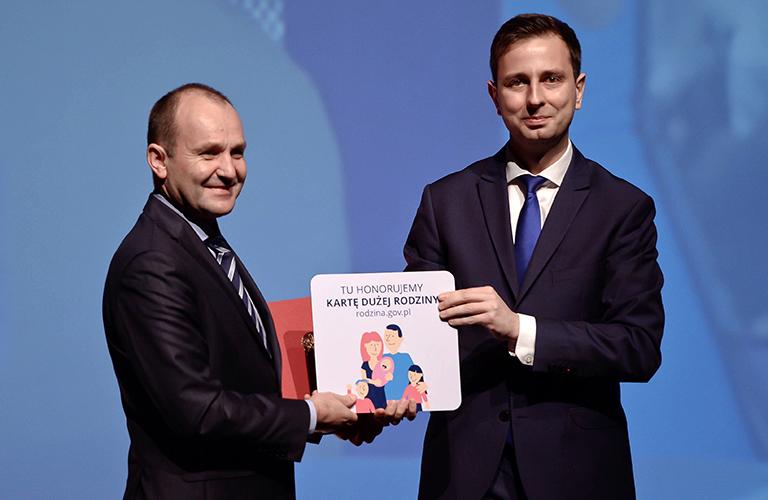 На фото: министр труда и социальной политики Польши Вадислав Косиняк-Камыш (справа) и Марек Сова (слева), маршал воеводства Малопольского края (польск.: Маршалек - Воеводство Два Малопольских), подписывают соглашение о партнерстве с 25 новыми предприятиями, которые присоединятся к Общенациональному Проект большой семейной открытки, 2014