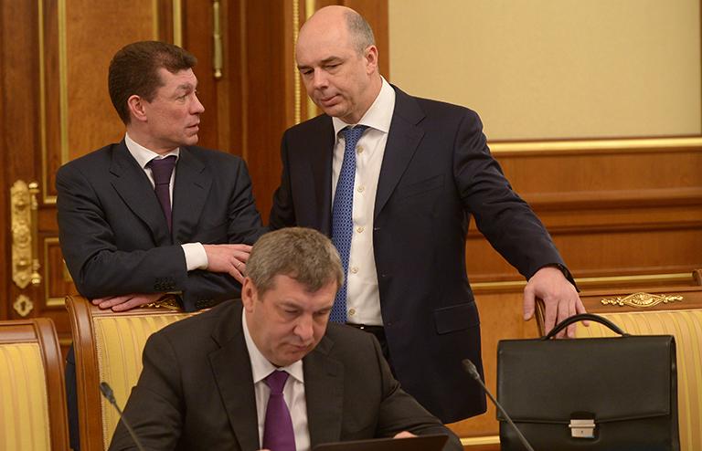 На фото: министр регионального развития РФ Игорь Слюняев (на первом плане), министр труда и социальной защиты Максим Топилин и министр финансов РФ Антон Силуанов (слева направо на втором плане) перед началом заседания правительства РФ, 2014
